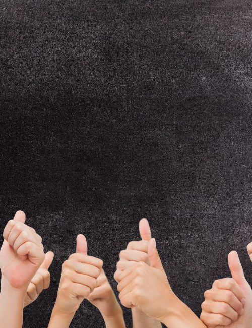 digital composite of multiple thumbs up on chalkboard background